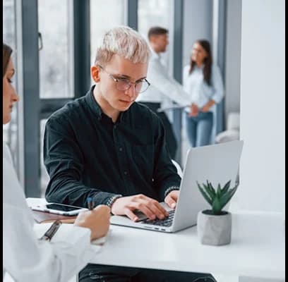 IT experts working together in office using laptop